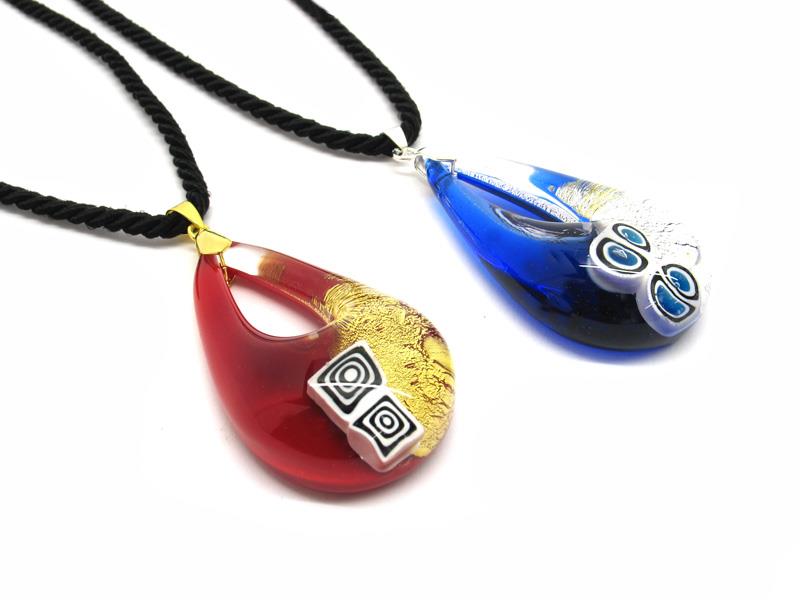 Murano glass bicolored drop Necklaces, 50x30 mm ( COLV0286 ) available in 6 colour, made entirely handmade by Murano master glass-makers with the lampwork technique, in our factory in Murano Venice - Italy, with silver 925 - gold 24kt foil, and Murrina insertions on the basis of transparent glass, twisted cotton cord in black color (50 cm